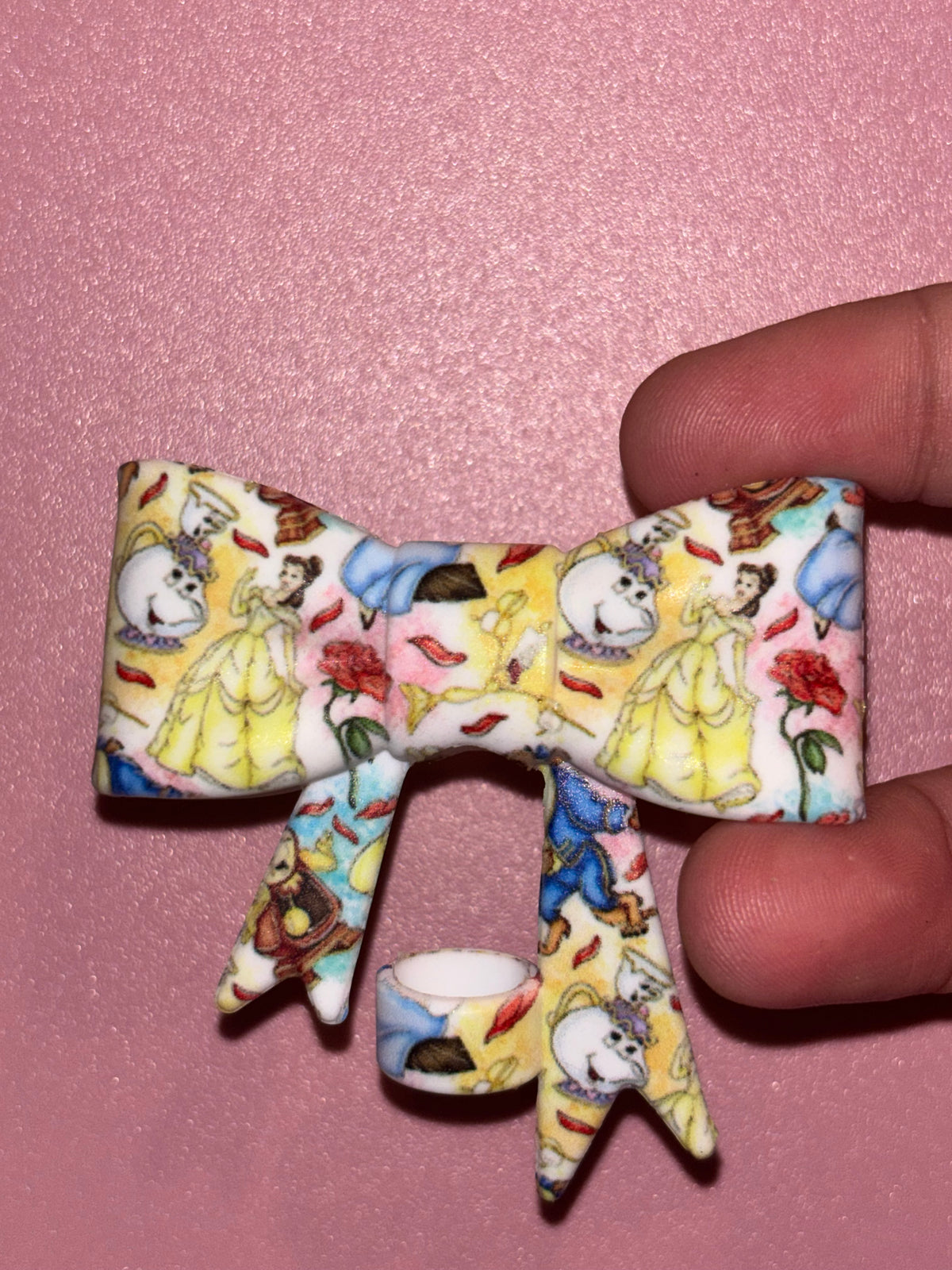 Light-colored bow featuring Belle, Mrs. Potts, the Beast, Cogsworth, red roses, and rose petals